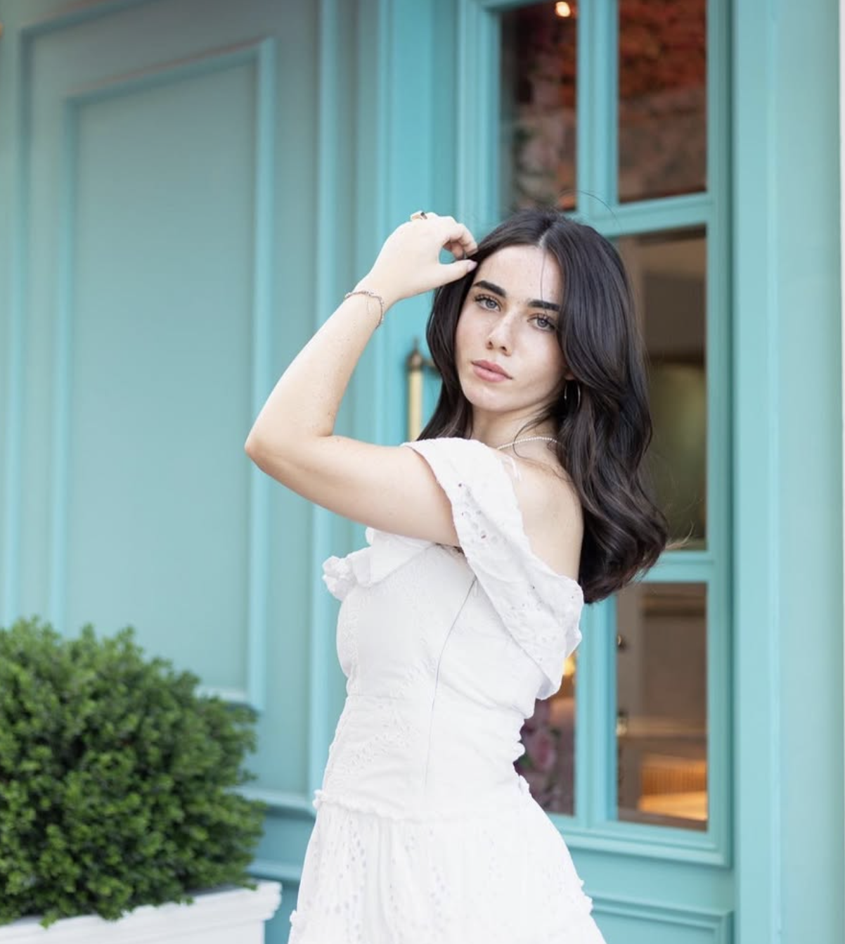Mirna standing beside turquoise doors